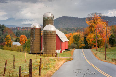 A quintessential red barn with three silos overlooks the quaint village of Waitsfield Vermont on a fall day | Capturing the rural character of Vermont  