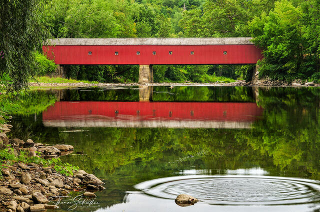 Summer serenity in Connecticut's Litchfield Hills - The placid Housatonic River reflects the bright red West Cornwall Covered bridge with mirror-like perfection