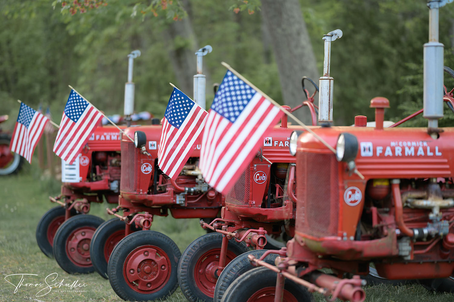 Americana takes its form as a line of red Farmall tractors are adorned with flags for the Independence Day holiday | Connecticut stock photography