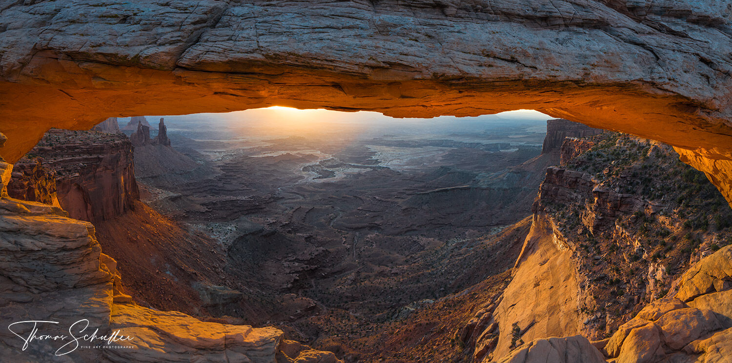 Awe-inspiring sunrise framed by Mesa Arch which overlooks the stunning Utah landscape of Buck Canyon in Canyonlands National Park